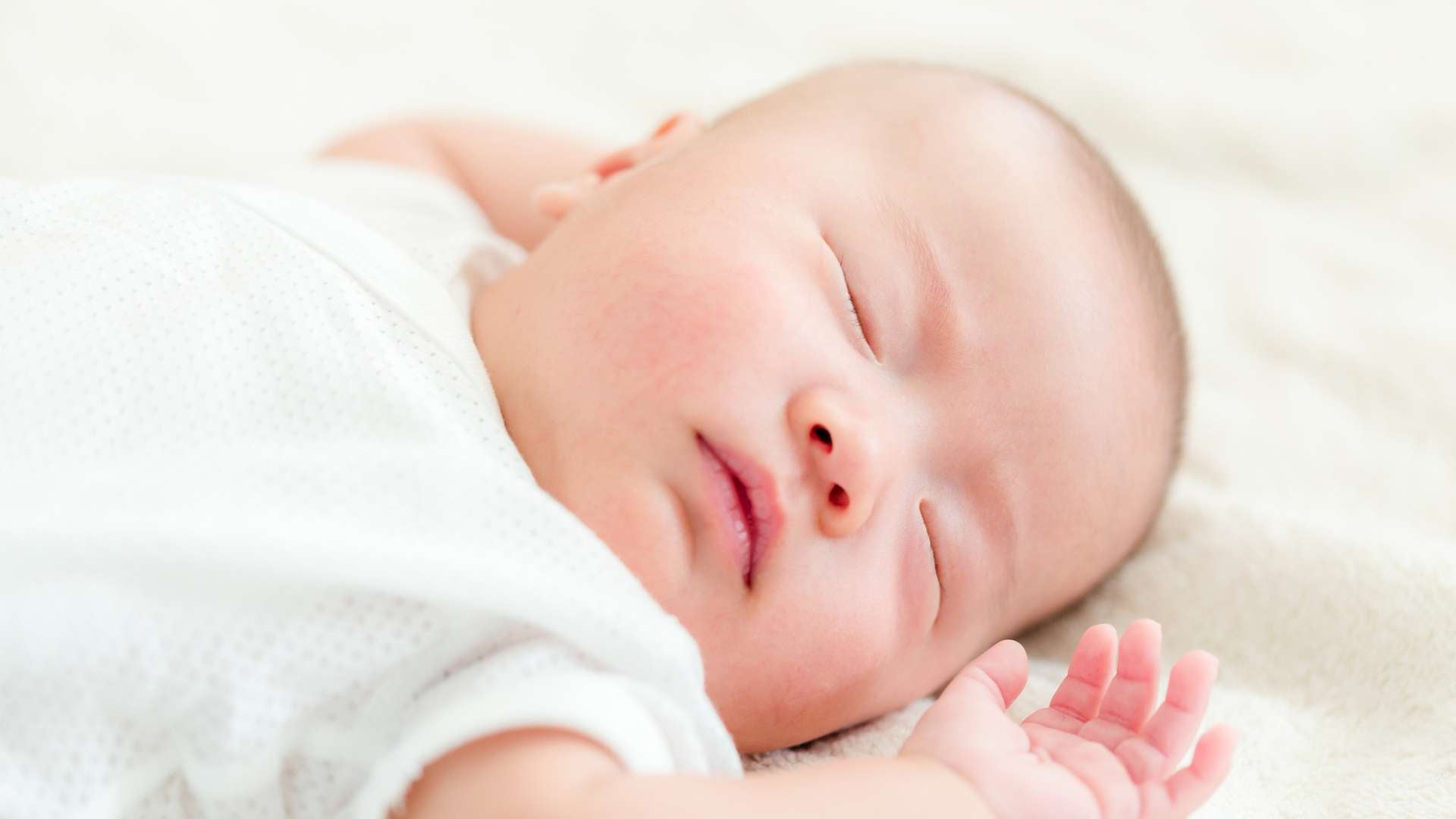 baby sleeping on organic crib sheet - flowing creations